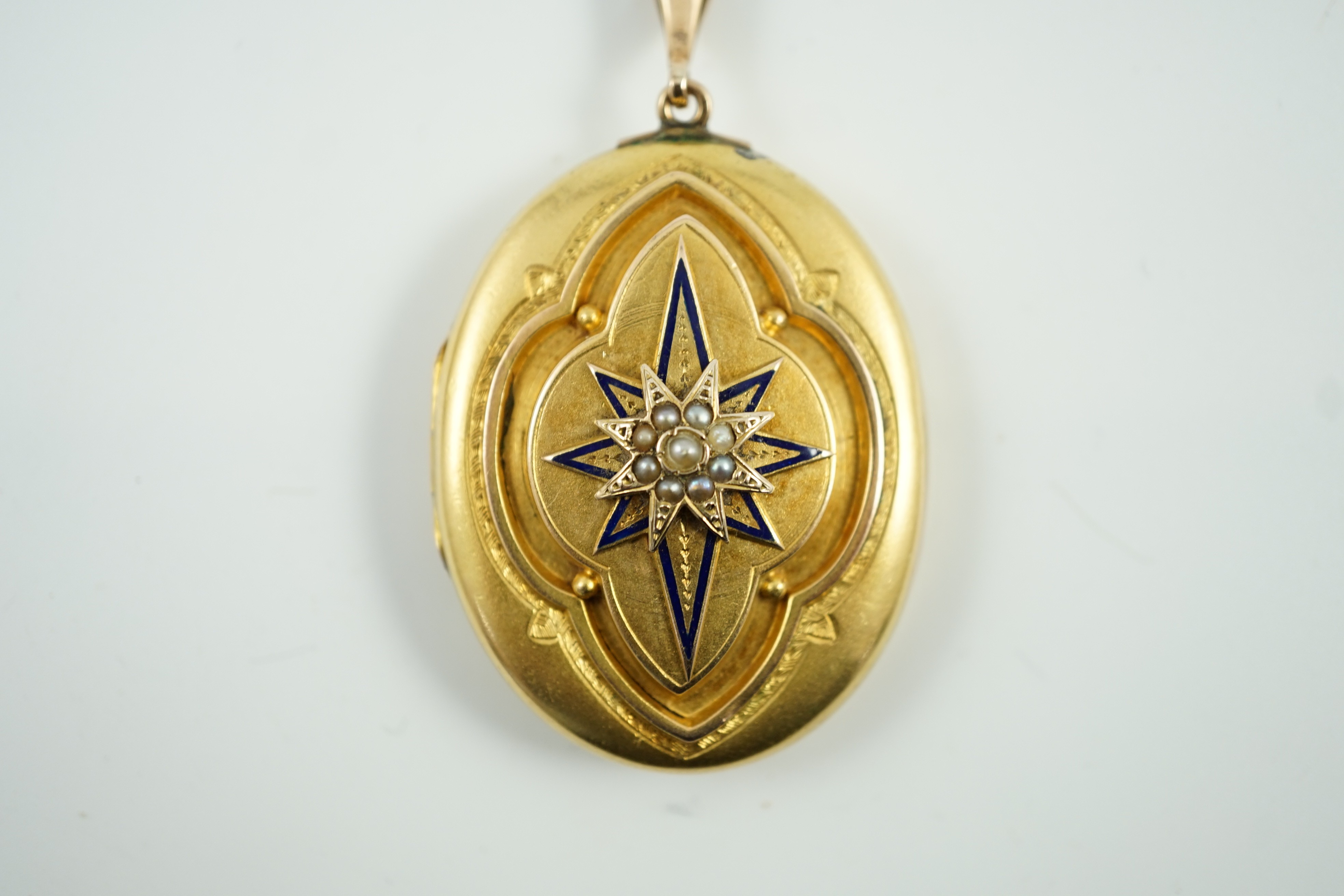 A Victorian yellow metal, blue enamel and seed pearl set oval locket, 40mm, gross weight 13.8 grams.